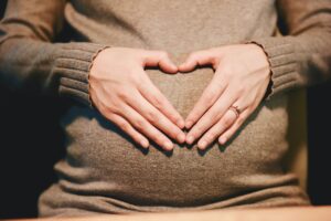אישה בהריון עם הידיים על הבטן
